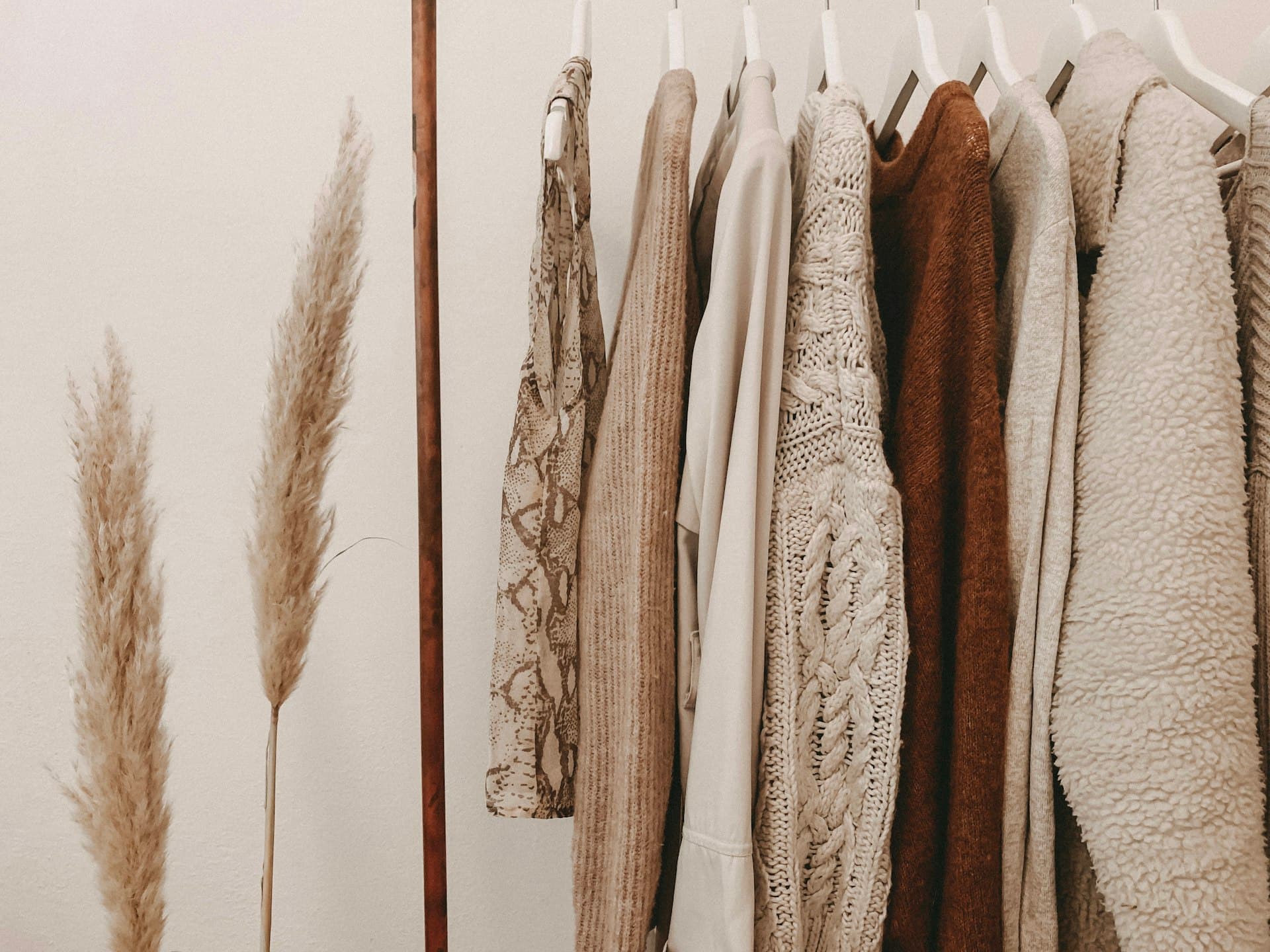 Neutral-toned knitwear hanging in a design studio