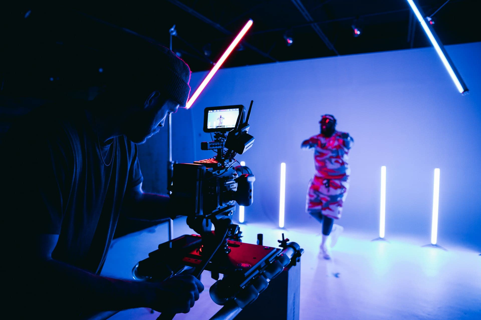 Content production studio with neon lights and camera operator
